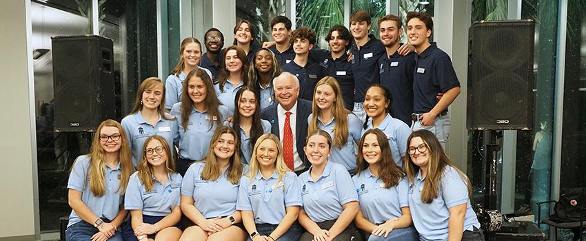 Students sitting on stage with President Bonner.